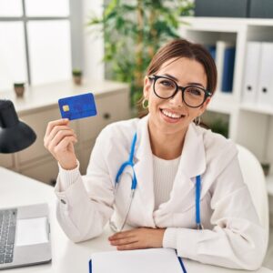 young-hispanic-woman-wearing-doctor-uniform-holding-credit-card-clinic_839833-10435